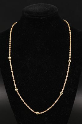un collier à chaîne en or sur un présentoir à mannequin