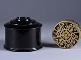 pair of black and gold boxes with a gold medallion on the lid