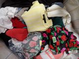 a pile of clothes in a basket on a bed