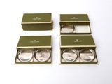 three green boxes with silver lids are sitting on a white surface