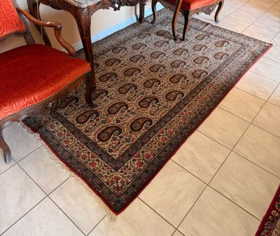 an image of a living room with red chairs and a rug