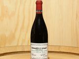 a bottle of wine sitting on top of a barrel