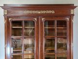 a large wooden cabinet with glass doors and gold trimmings