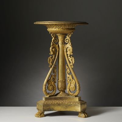 une table richement sculptée, dotée d'un piédestal, sur un fond blanc