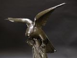 a statue of a bird sitting on a tree stump