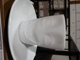 un vase blanc posé sur une table, à côté d'une boîte marron