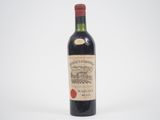 une bouteille de vin rouge posée sur une table blanche