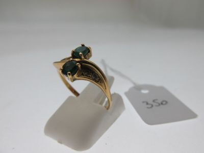 l'image d'une bague en or ornée d'une pierre verte