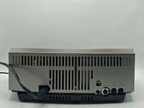 a close up of a silver amplifier on a white surface