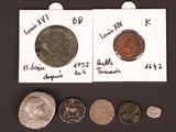 several different types of coins are shown on a black surface