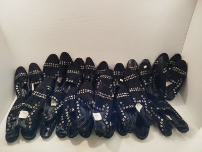 Plusieurs paires de chaussures en cuir noir sont alignées en rangée
