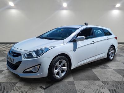 une voiture blanche garée dans une pièce au sol en damier