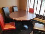une table entourée de quatre chaises dans une pièce