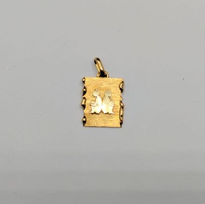 a close up of a gold plated pendant with a dog on it