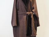 manteau marron et noir sur un pied de mannequin, avec une écharpe noire
