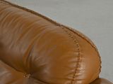 a close up of a brown leather couch on a concrete floor