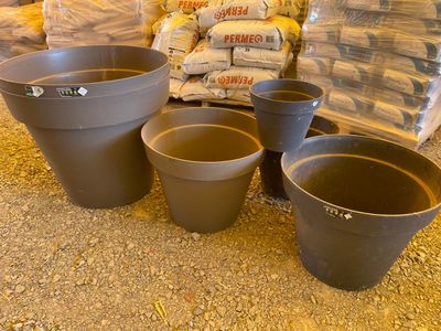 de nombreux pots posés par terre les uns à côté des autres