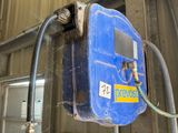 un réservoir bleu auquel est raccordé un tuyau, à l'intérieur d'un bâtiment