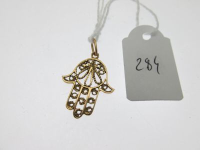 un pendentif en forme de main de Hamsa en or, sur lequel est accrochée une étiquette de prix