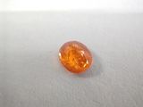 an orange colored stone sitting on top of a white surface