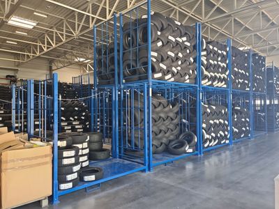many stacks of tires in a warehouse with pallets