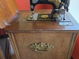 a sewing machine sitting on top of a wooden cabinet