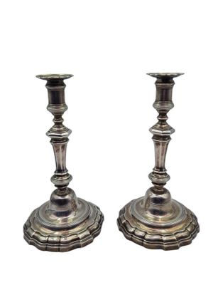 une paire de bougeoirs anciens en argent sur des socles, sur fond blanc