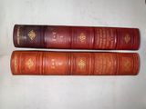 two old books sitting on top of each other on a table