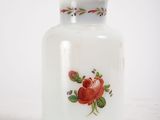a white glass jar with a red rose design on it