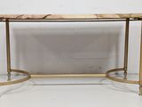 a gold console table with a marble top and metal legs