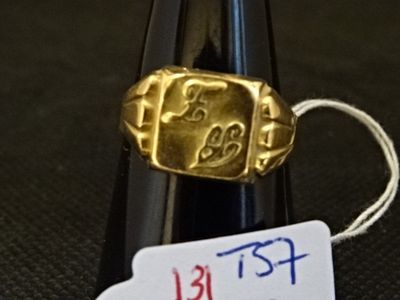 une bague en or posée sur un cône noir, avec une étiquette de prix dessus
