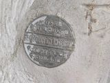 a silver coin sitting on top of a cement slab