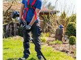 Cet homme utilise une débroussailleuse filaire pour tailler le gazon.