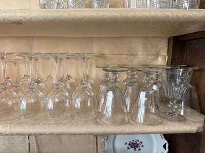 de nombreux verres à vin posés sur une étagère dans la cuisine