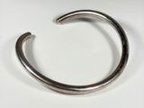 a close up of a metal bracelet on a white surface