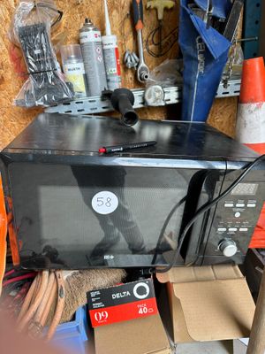 a microwave sitting on top of a box in a garage