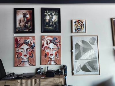 de nombreuses photos accrochées au mur au-dessus d'un bureau dans une pièce