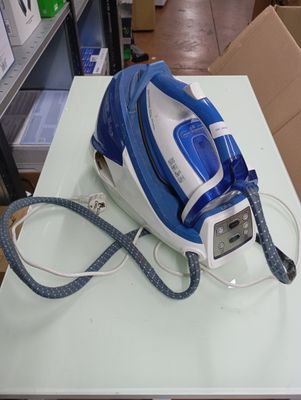a blue and white steam iron sitting on a white table