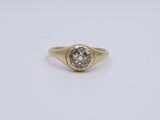 a yellow gold ring with a single diamond in the center
