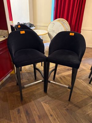 two black chairs sitting on top of a wooden floor next to a table