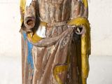 une statue ancienne d'une femme tenant un bébé dans ses bras