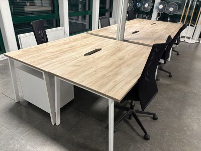 deux bureaux avec des chaises et un ventilateur à l'arrière-plan