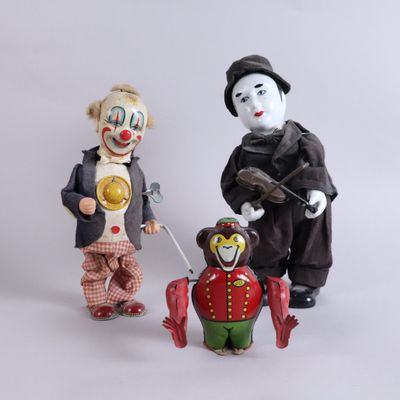 two clowns standing next to each other on a white surface