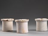 three white vases sitting on top of a table next to each other