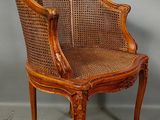 an image of a wooden chair with wicker back and arms