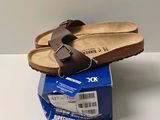 a pair of sandals that are on top of a box
