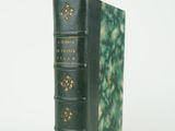 un livre vert posé sur une surface blanche