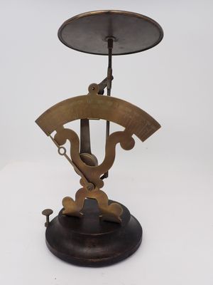 une vieille balance en laiton surmontée d'une horloge