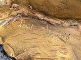 a gold statue of a person sitting on a rock