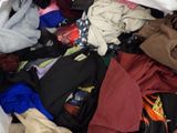 a pile of clothes in a white bag on the floor